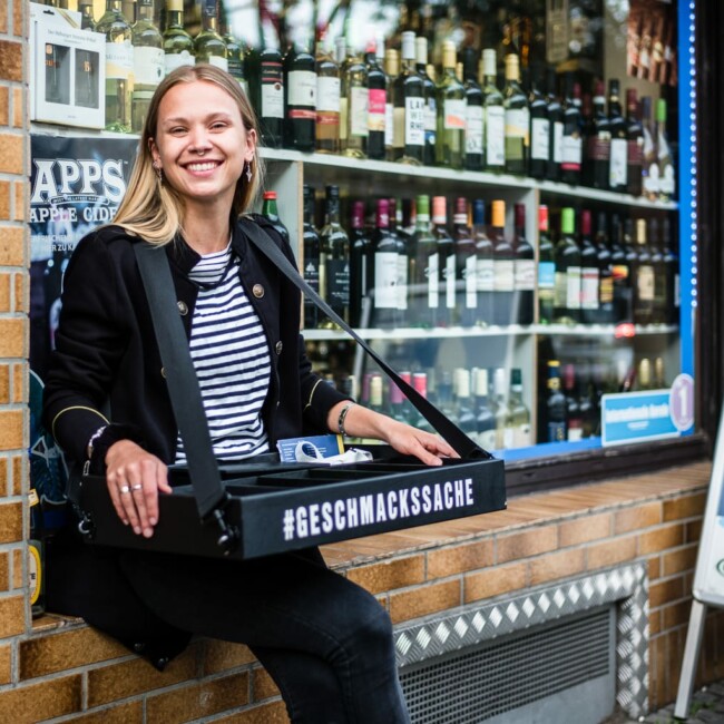 Frau sitzt auf der Fensterbank vor dem Kiosk