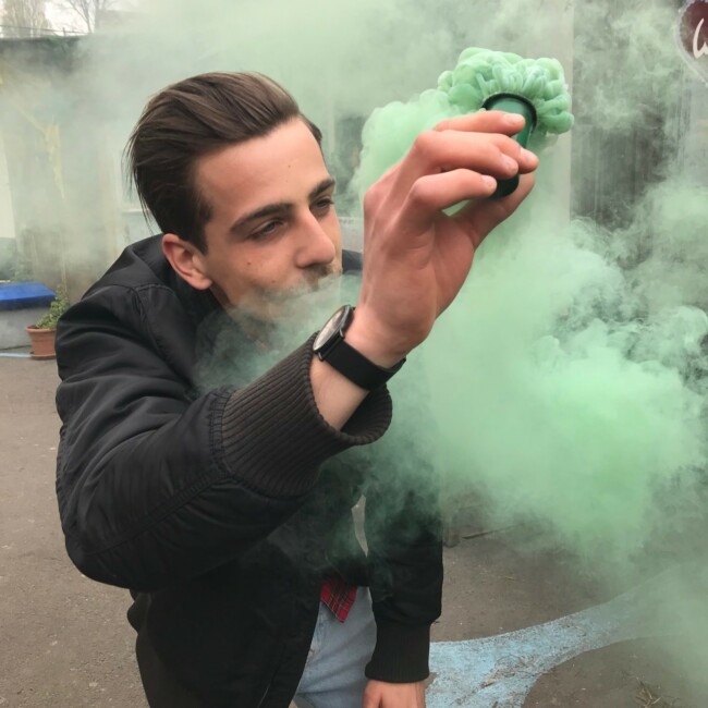 Mann verteil grüne Holi Farbe in der Luft